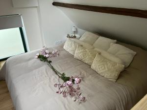 a white bed with a flower arrangement on it at Le domaine des amours in Saint-Josse