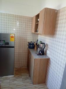 een kleine keuken met houten kasten en een aanrecht bij Chambre et Salon in Agboogba +15 foto's