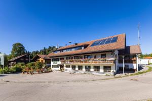 un gran edificio con paneles solares en el techo en Goldiger Hirsch B&B mit Kochmöglichkeiten, en Immenstadt im Allgäu