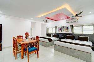 a hotel room with two beds and a table at Collection O Karmanghat Bus Terminal Hyderabad Formerly Hotel Chirag Stays in Hyderabad