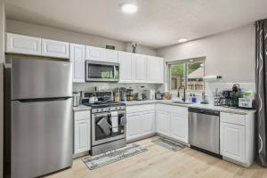 サンアントニオにあるCozy 3BR Home Family-Friendly Near Attractionsの白いキャビネットとステンレス製の冷蔵庫を備えたキッチン