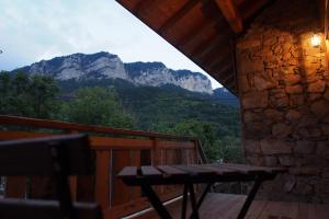 a wooden balcony with a table and mountains in the background at Chez Julie in Thollon