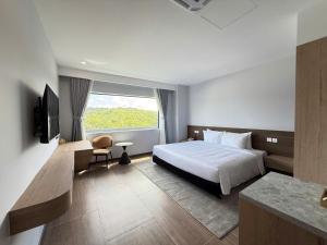 une chambre avec un lit et une grande fenêtre dans l'établissement Amarin Resort & Spa Phu Quoc, à Duong Dong