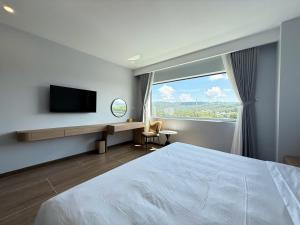 une chambre avec un lit, une télévision et une fenêtre dans l'établissement Amarin Resort & Spa Phu Quoc, à Duong Dong