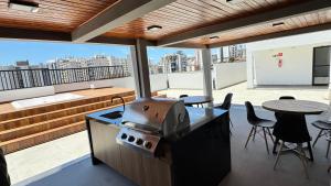 a outdoor kitchen with a grill on a roof at Studio Moderno com automação e vista incrível in Juiz de Fora