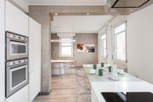 eine Küche mit weißer Theke und ein Esszimmer in der Unterkunft Flats4rent Verona Elegance Luxury Apartment in Verona