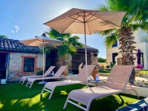 a group of chairs and umbrellas in a yard at Tramontana Casetta in Castilenti