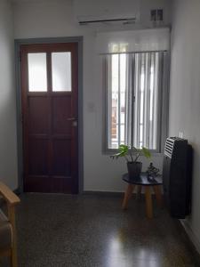 Zimmer mit Tür und Tisch mit Pflanze in der Unterkunft La Estrella - alojamiento temporario in La Plata