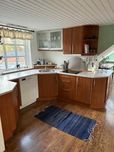a kitchen with wooden cabinets and a sink and a counter at Tylstrup Nordjylland in Tylstrup +7 photos