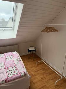 a attic room with a bed and a window at Tylstrup Nordjylland in Tylstrup