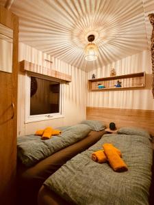 two beds with stuffed animals on them in a room at Cozy Mobile Home 'Tante Truus' met privé infrarood sauna - Recreatiepark 't Veluwshof - VELUWE in Hoenderloo