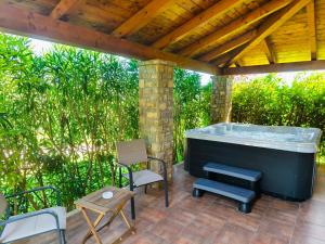 Un jacuzzi en un patio con sillas y una mesa. en Villa Dol, en Buzet