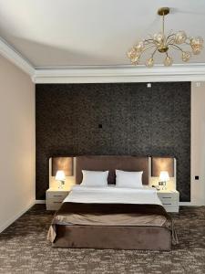 een slaapkamer met een groot bed met twee nachtkastjes bij Marison Hotel Baku in Baku +30 foto's