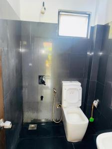 ティッサマハーラーマにあるHotel Winrose Tissamaharamaの白いトイレと窓のあるバスルーム