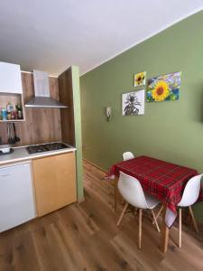 a kitchen and dining room with a table and chairs at Il Sole di Ester in Branzi +12 photos