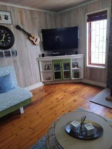 Una sala de estar con un televisor de pantalla plana en una pared. en Zen-Vibes Holiday Home, en George