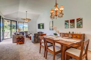 a dining room and living room with a table and chairs at Grand Champions 124 · GC 124 3BD Wailea Condo wAC Pool Hot Tub in Wailea