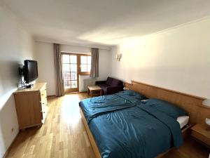 a bedroom with a bed and a couch and a television at Select Apartment TOP 8 Kaprun Fürth by Jara in Piesendorf