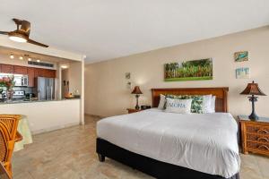 a bedroom with a large bed and a kitchen at Mahana 713 · MA 713 Luxury OceanFront Studio in Kahana +42 photos