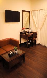 a living room with a couch and a table at Ello Hotels in Bengaluru +21 photos