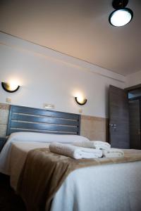 a bedroom with two white towels on a bed at Pensión Juan Pedro in Roquetas de Mar