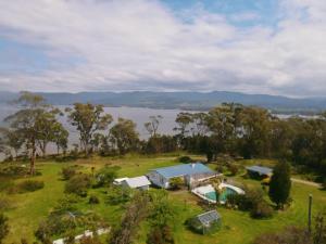 an aerial view of a house in a field with a body of water at The Seaside House - A little gem by the sea in Tinderbox