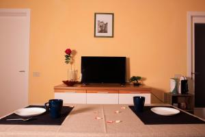 a living room with a flat screen tv and two white bowls at La Corte Segreta - Dimora nel cuore di Urbino in Urbino +3 photos