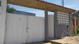 a white fence in front of a house at Alzira casa completa Iguaba in Iguaba Grande
