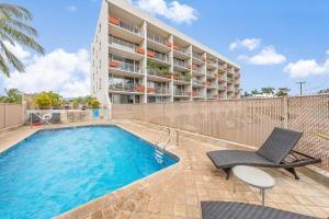 a swimming pool with a chair and a building at Island Surf 306 · ISF 306 1BD w Ocean Views AC Pool Near Beach in Kihei