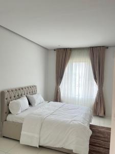 Un dormitorio blanco con una cama grande y una ventana. en Ambleton Haven & Ambleton Crest, en Ikate 16 fotos más