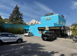 een blauw gebouw met auto's geparkeerd op een parkeerplaats bij Sol Rio De Alverca in Quinta da Verdelha