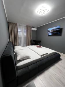 a bedroom with a large bed with a black couch at ApartPoltava 1-bedroom з великою кухнею та шикарною панорамою на АНТОНА ГРИЦАЯ,10 in Poltava +7 photos
