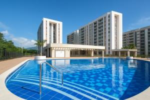 a swimming pool with two tall buildings in the background at APARTAMENTO FAMILIAR VILLETA in Villeta
