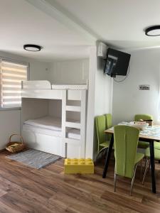 a bedroom with a bunk bed and a table and chairs at Cozy Family Stay in Terme Čatež - Free Tickets and Thoughtful Touches in Čatež ob Savi