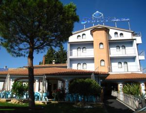 un edificio con un albero di fronte di Hotel Cristoforo Colombo a Osimo
