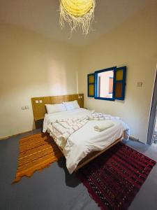 ein Schlafzimmer mit einem Bett und einem Teppich auf dem Boden in der Unterkunft Sunrise Camp in Mirleft