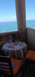 Maison Au bord de la mere في Mostaganem: طاولة في غرفة مطلة على المحيط