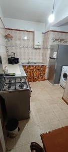 Maison Au bord de la mere في Mostaganem: مطبخ مع موقد ومغسلة