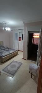 Maison Au bord de la mere في Mostaganem: غرفة نوم بسرير وباب للحمام