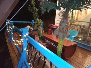 a balcony with a palm tree and a blue railing at 絶景ゴンドラヴィライン熱海1階 in Atami