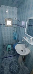 Maison Au bord de la mere في Mostaganem: حمام مزود بحوض ومِرآة