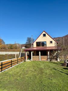 ein Haus mit einem Zaun vor einem Feld in der Unterkunft Vikendica MILA in Kolašin + 21 Fotos