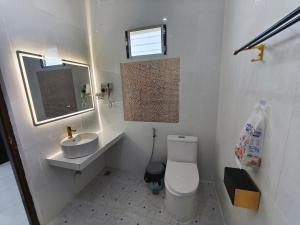 ein weißes Badezimmer mit Toilette und Waschbecken in der Unterkunft Vang Vieng Cozy Villa in Vang Vieng + 11 Fotos