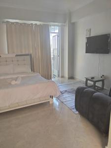 a bedroom with a bed and a flat screen tv at Luxe Homes in Meru
