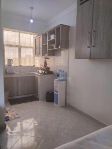 a kitchen with wooden cabinets and a tile floor at Luxe Homes in Meru