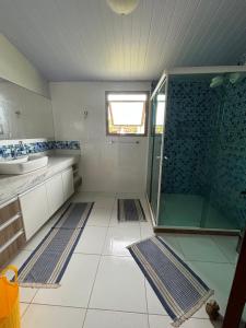 a bathroom with a glass shower and a sink at Casa Confortável - Cabo Frio in Cabo Frio +20 photos
