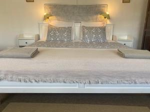 a large white bed with two pillows on it at Casa Morgado do Casco in Estremoz