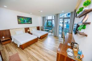 a hotel room with two beds and a desk at Hotel Anh Đức 2 in Ga Phú Văn