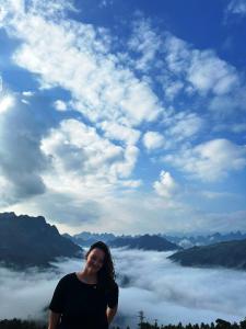 a woman standing on top of a mountain with clouds at Placement For Cloud Hunting in Suy Tung Su