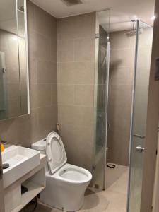 a bathroom with a toilet and a glass shower at The Sóng Homestay Vibes by the Sea in Vung Tau